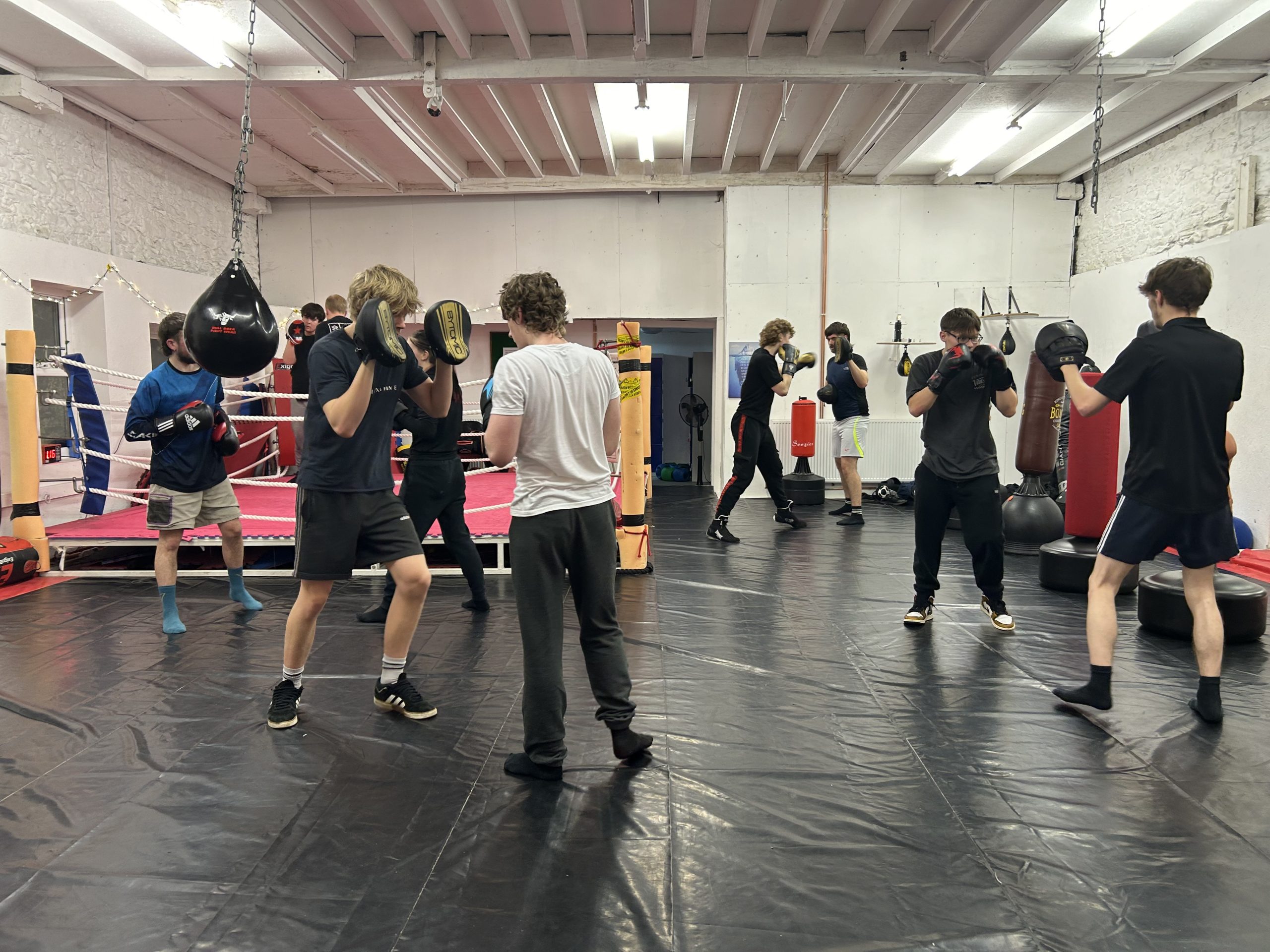 A group of young people are working out in a boxing gym